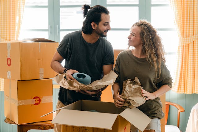 Couple smiling at each other while packing for their NYC move